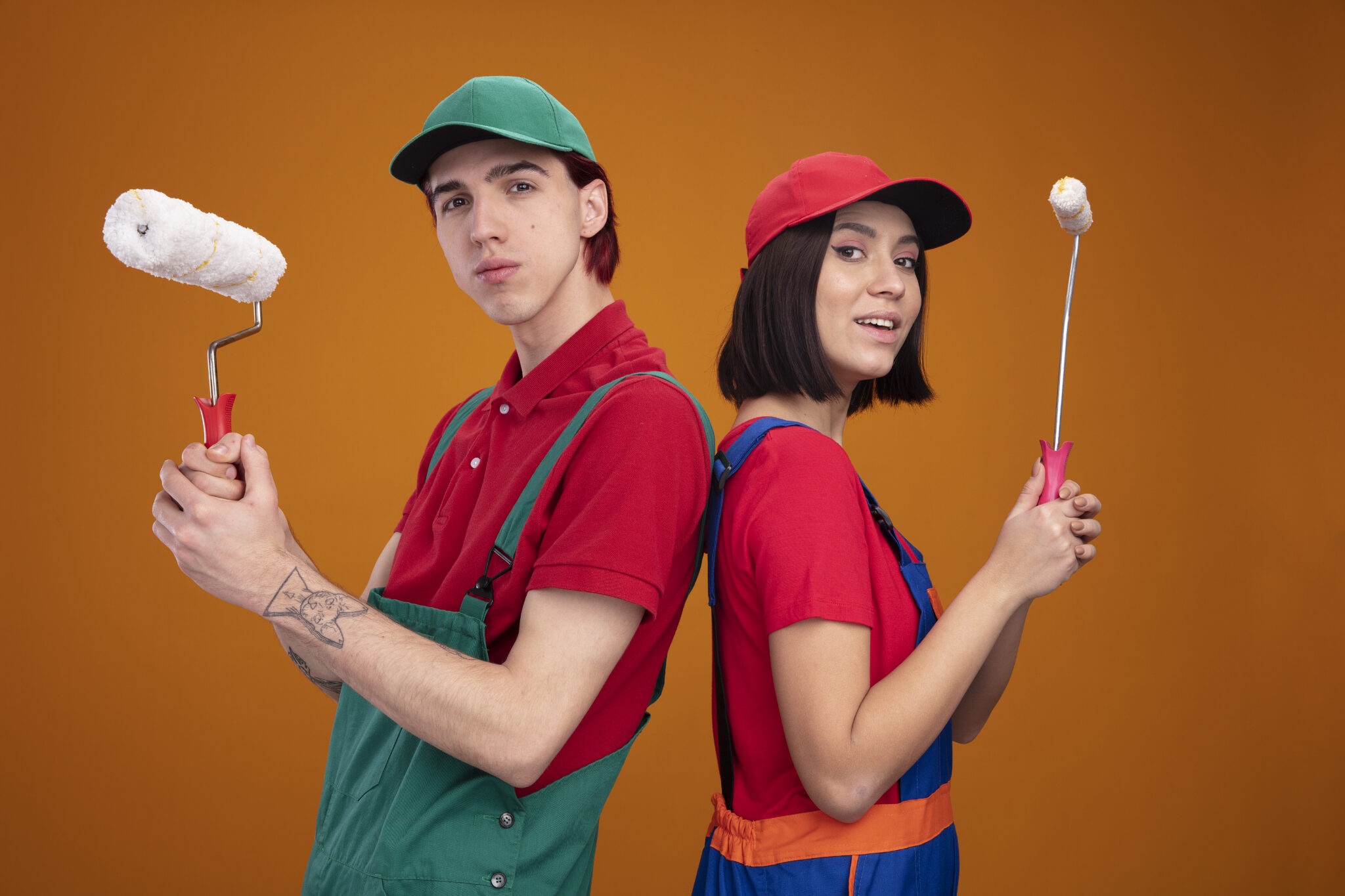"Two confident daily helpers in colorful uniforms holding paint rollers, ready to provide reliable home services like painting, plumbing, and repairs."