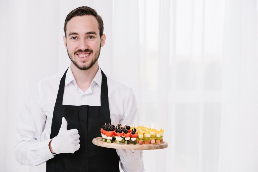 Catering boys serving food at an event in uniform